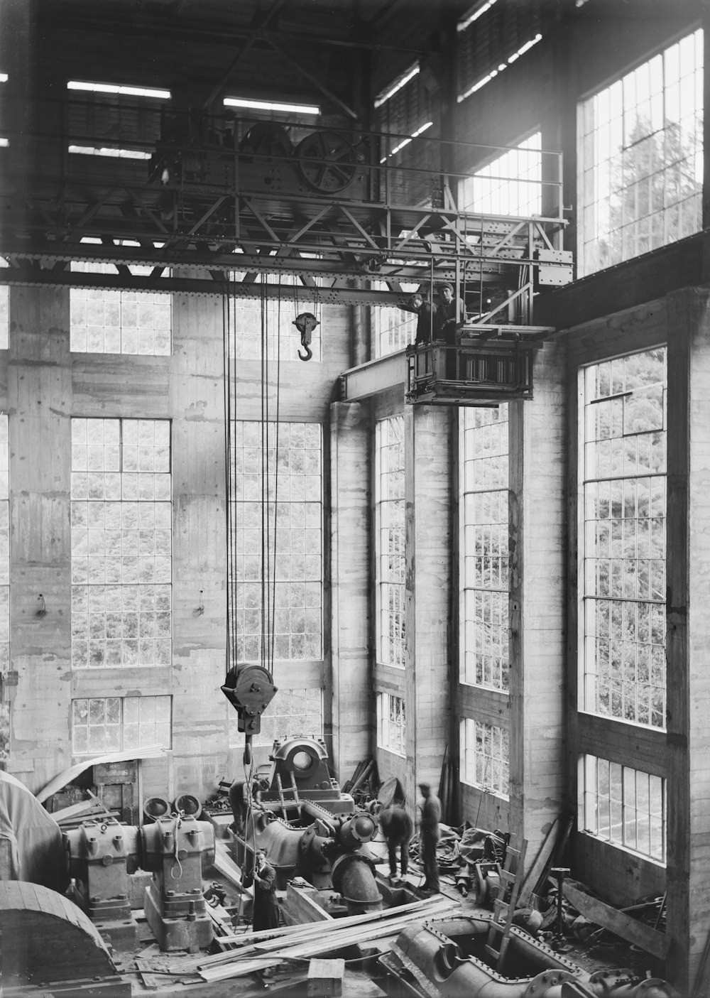 a black and white photo of men working in a factory