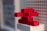 Red LEGO bricks are stacked in an abstract shape against a background of a LEGO baseplate.