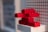 Red LEGO bricks are stacked in an abstract shape against a background of a LEGO baseplate.