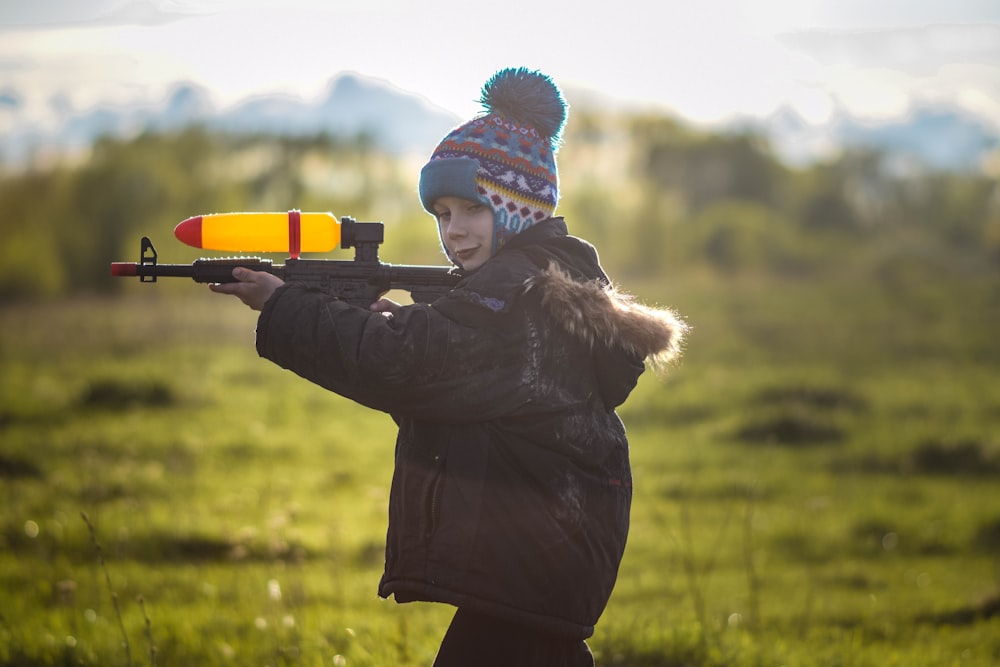 a woman holding a rifle in a field