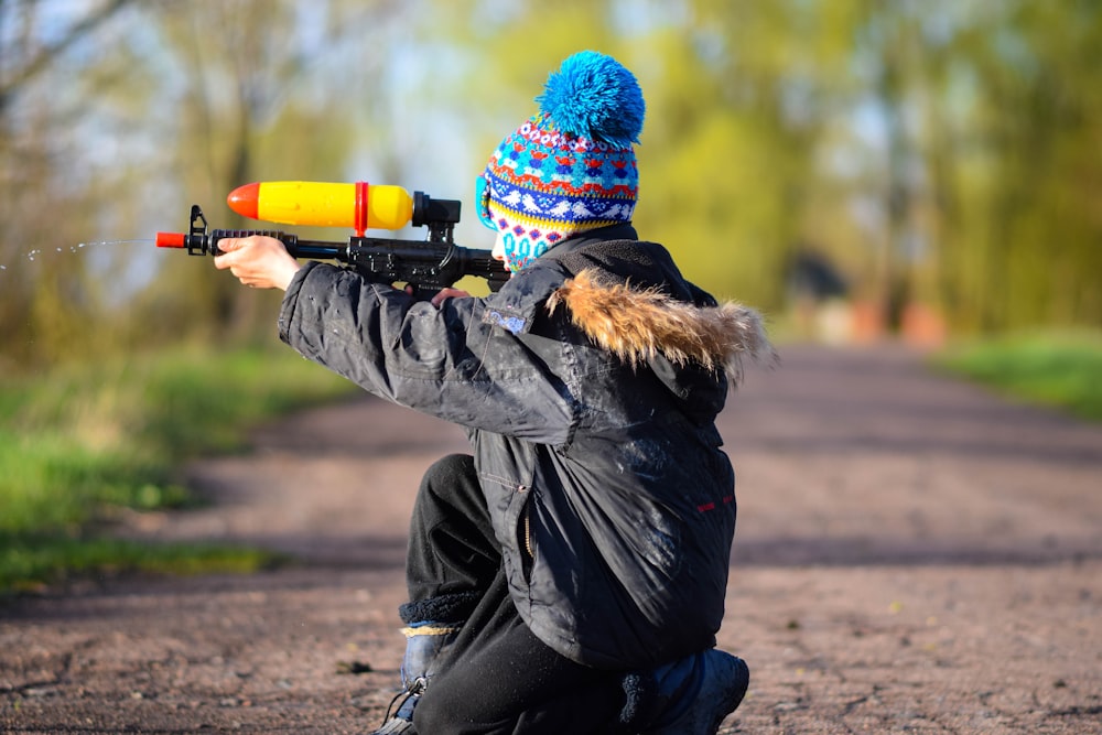 a person sitting on the ground with a gun