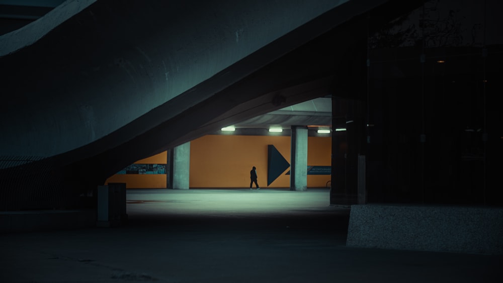 a person walking in a parking garage at night