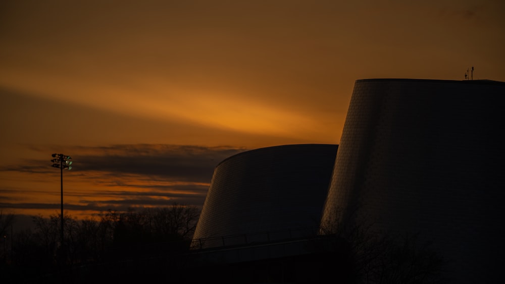 the sun is setting behind a cooling tower