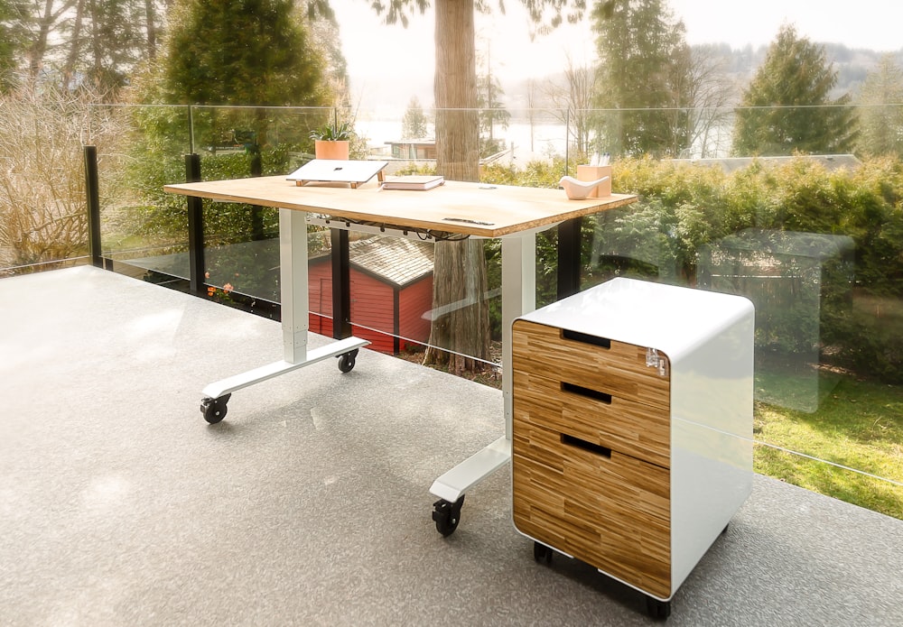 a computer desk sitting on top of a wooden table