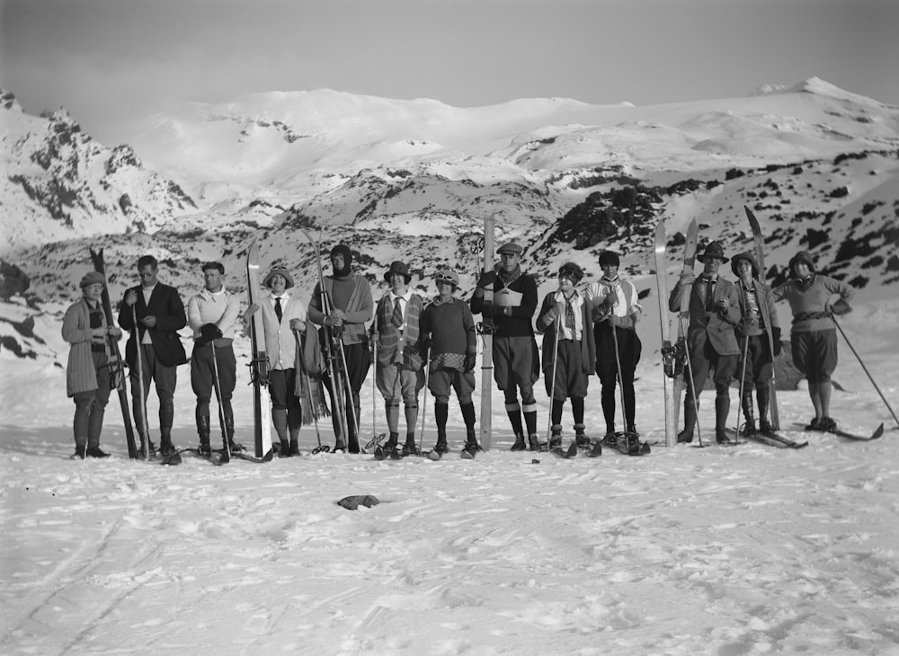 a group of men standing on top of a snow covered slope