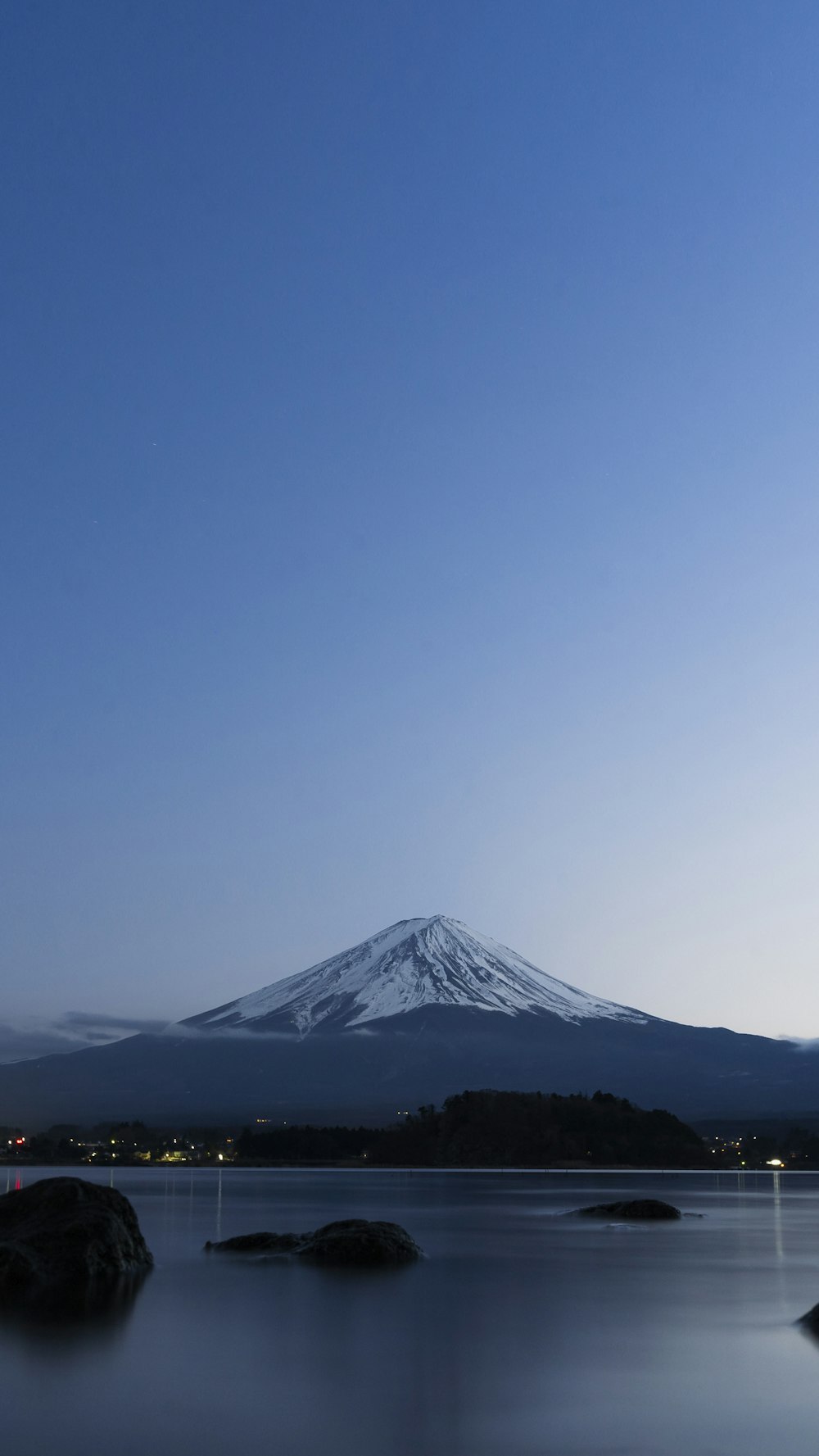 a mountain is shown in the distance with a body of water in front of it