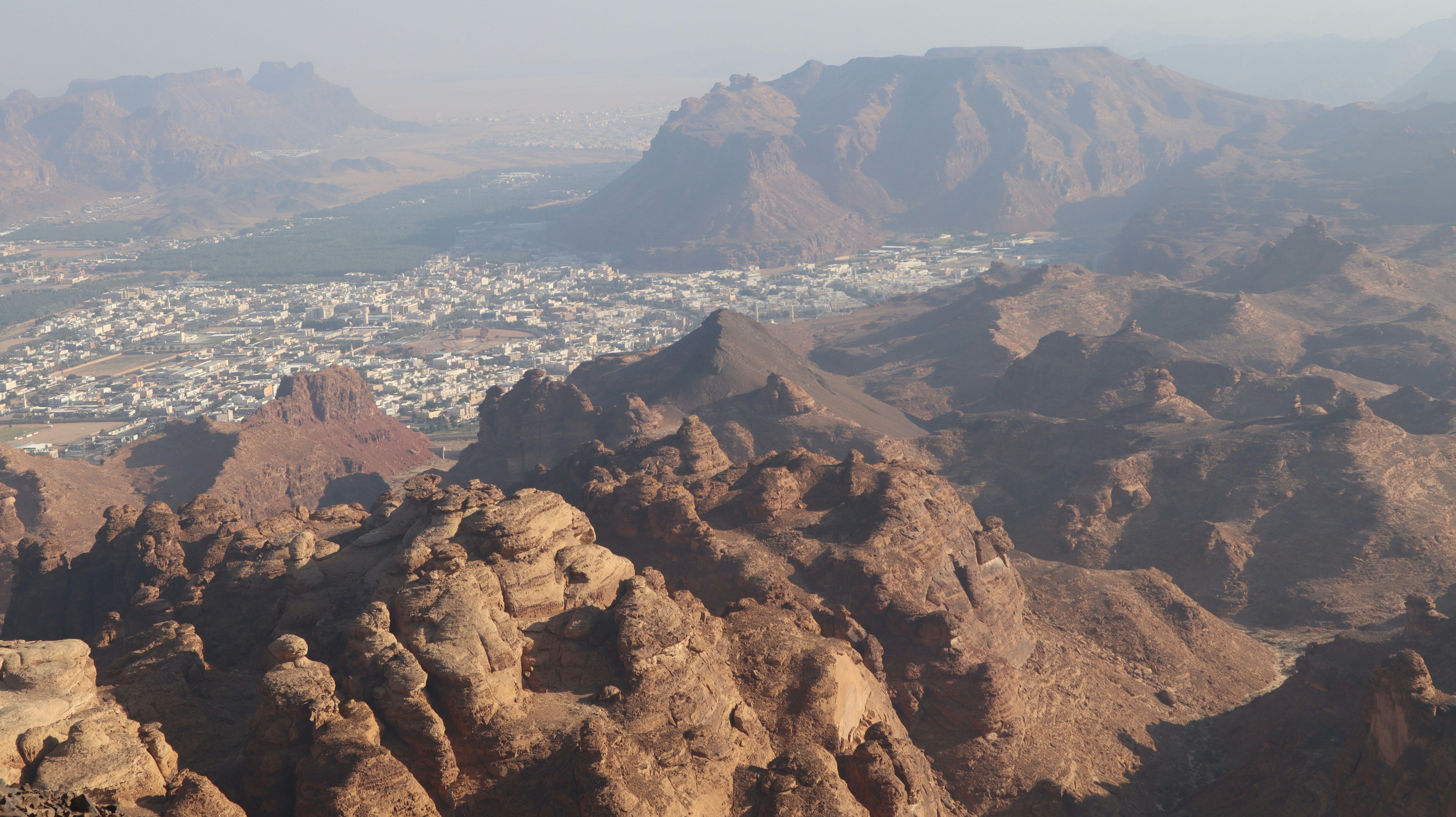 a view of a city in the distance from a mountain, Harrat Viewpoint