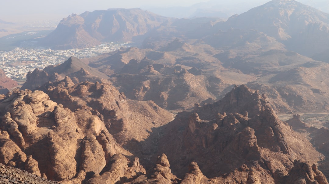 a mountain range with a city in the distance, Harrat Viewpoint