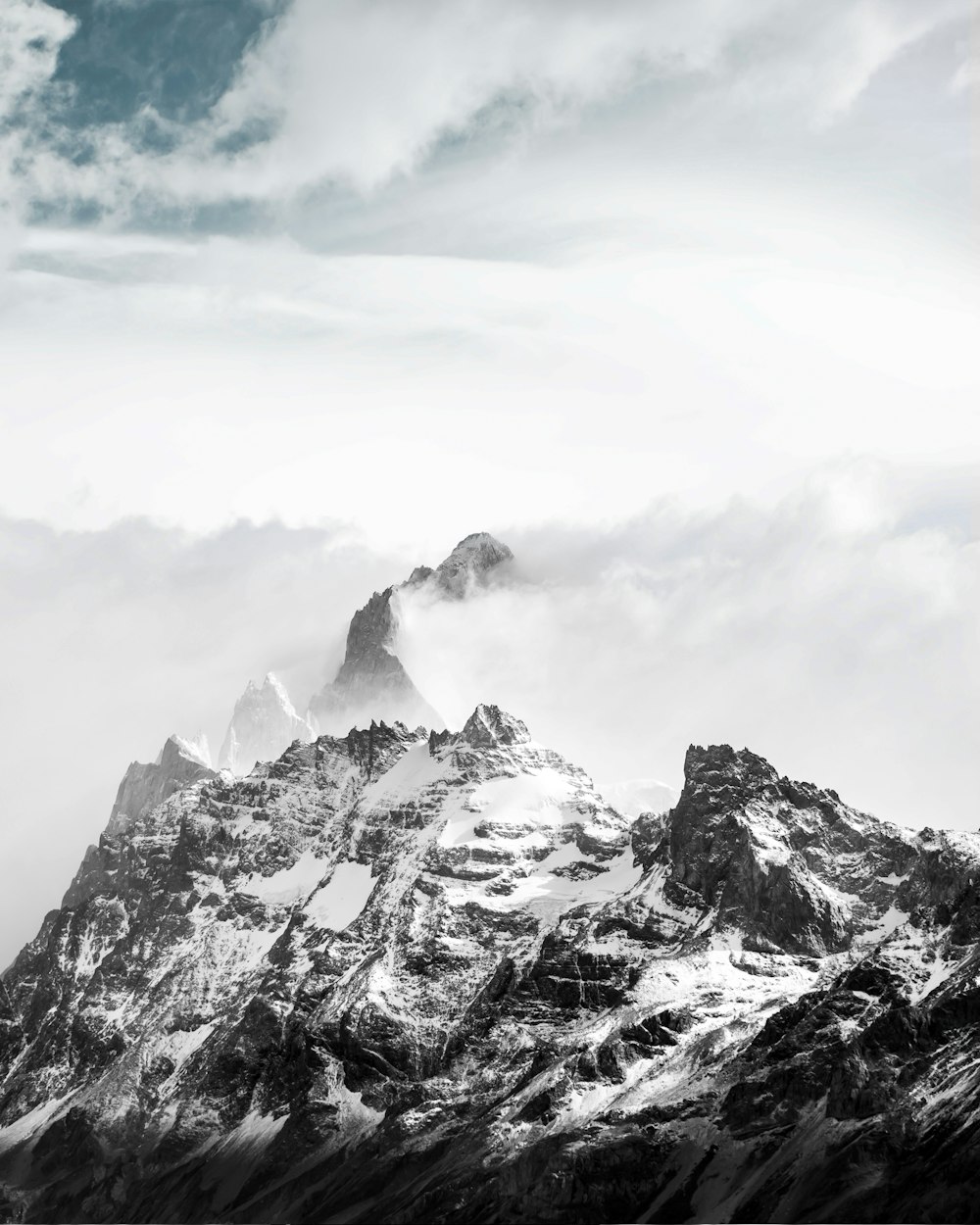 a black and white photo of a snowy mountain