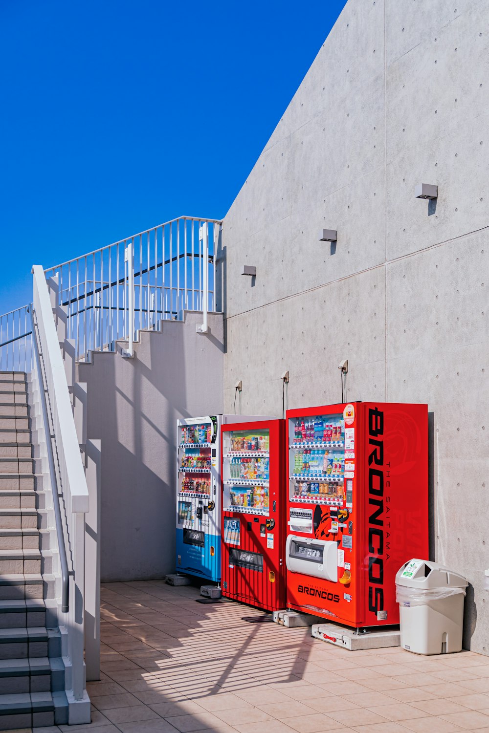 a row of vending machines sitting next to a stair case