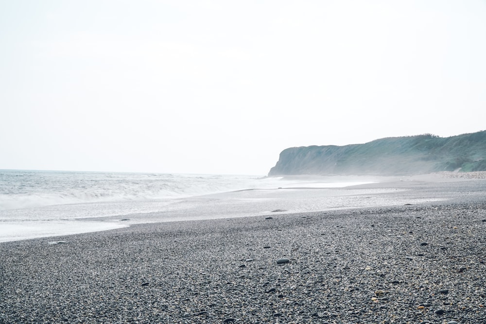 a person walking on a beach next to the ocean