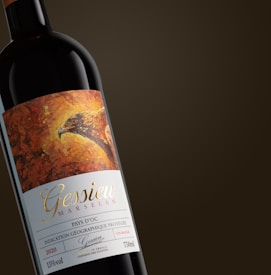 A wine bottle featuring an artistic label with an illustration of a bird's head against an abstract, warm-colored background. The label includes text detailing the brand 'Gessieu', the grape variety 'Marselan', and additional specifications such as the wine origin 'Pays d'Oc', the year '2020', and its alcoholic content of 15% vol.