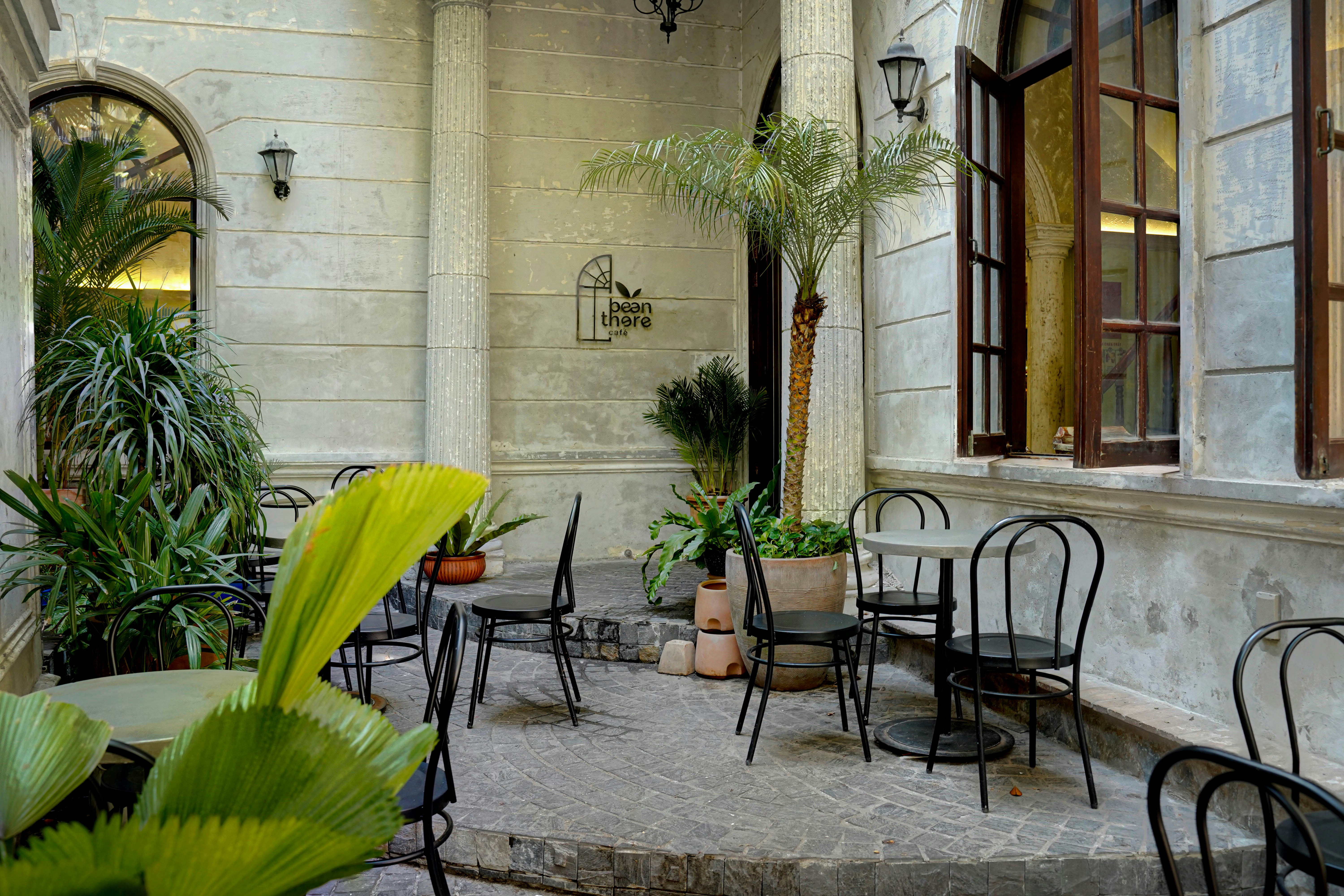 a courtyard with tables and chairs and potted plants