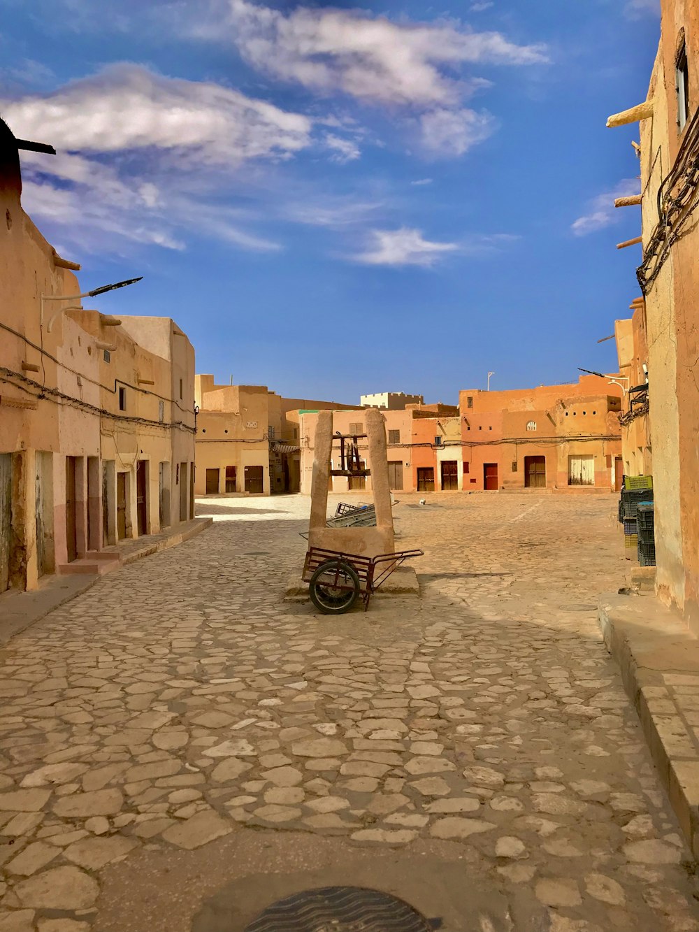 an empty street with a bench in the middle