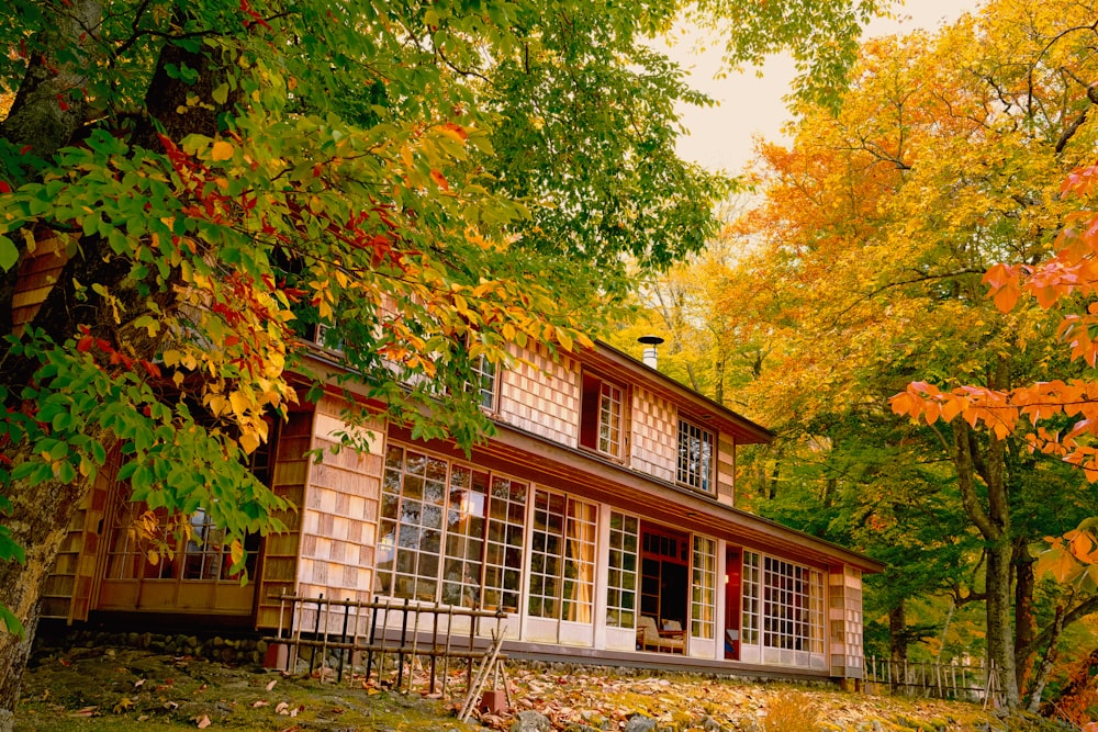 a small house surrounded by trees in the fall