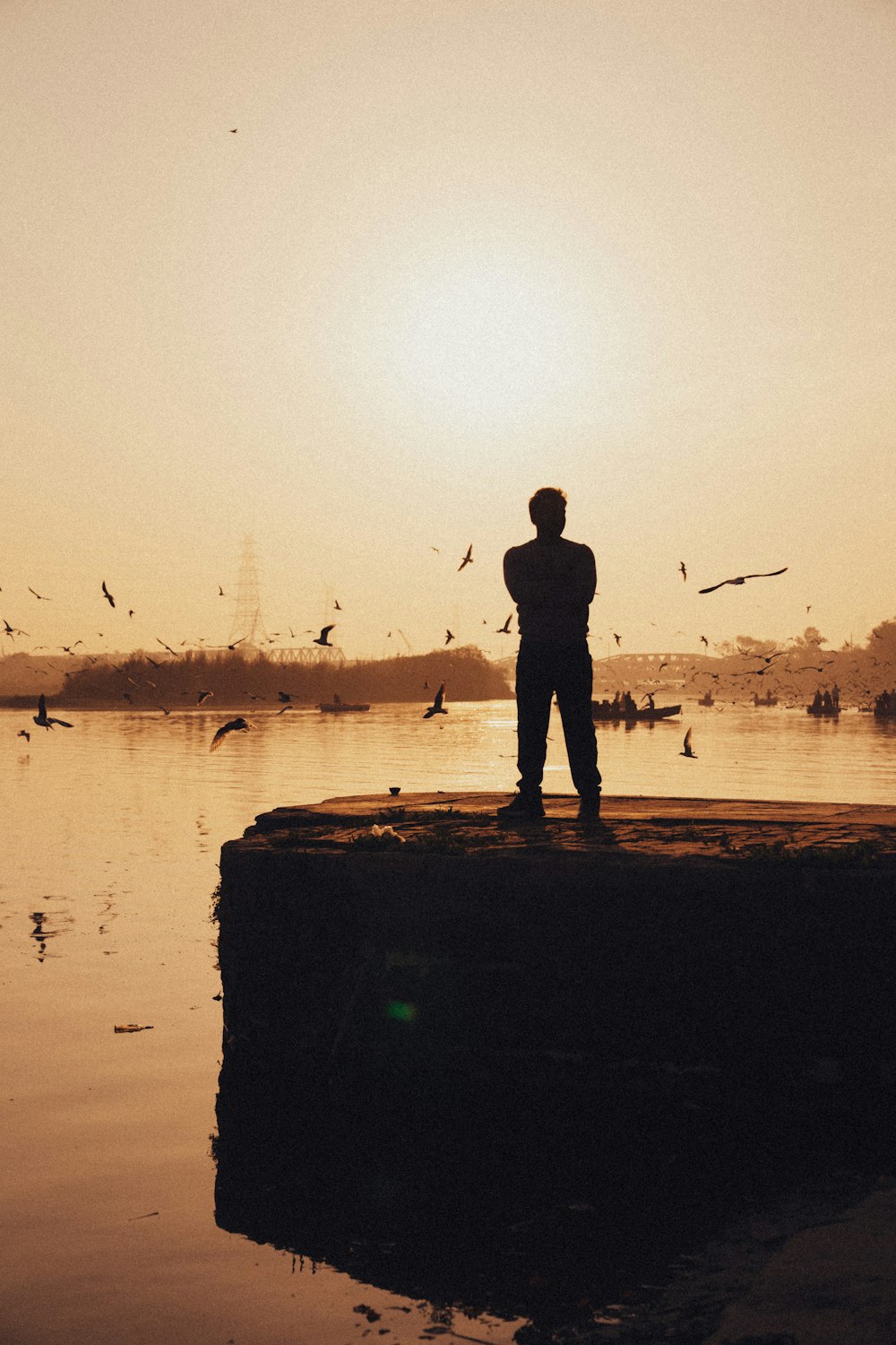 a man standing on a rock in front of a body of water