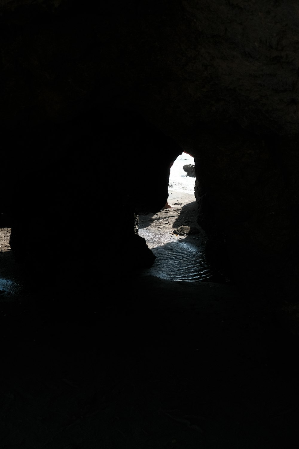 a dark cave with water coming out of it