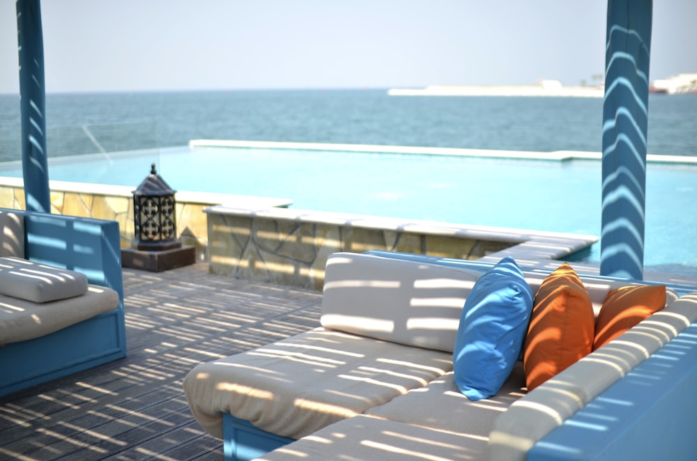 a blue and white couch sitting on top of a wooden deck