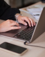 a person typing on a laptop on a table