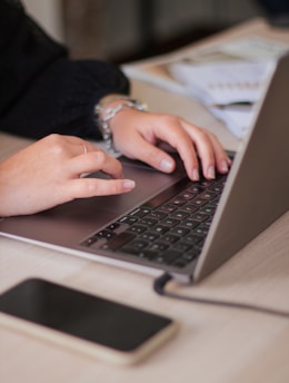 a person typing on a laptop on a table