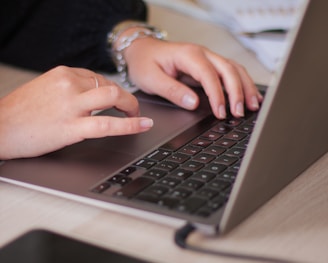 a person typing on a laptop on a table