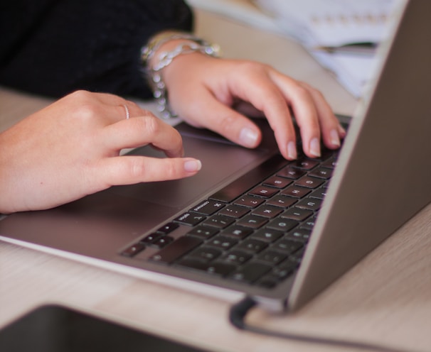 a person typing on a laptop on a table