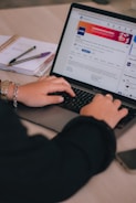 a woman is typing on a laptop computer