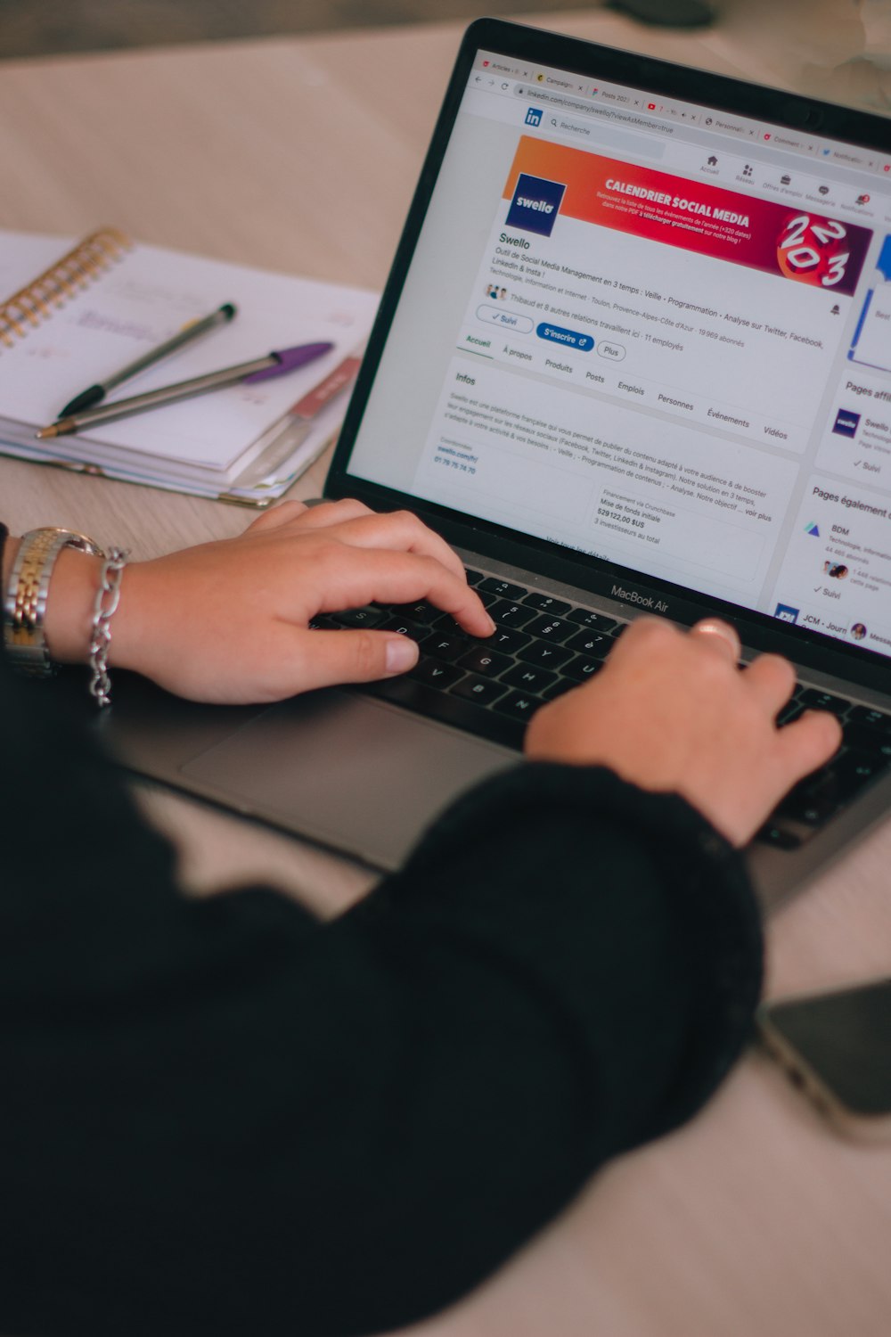 a woman is typing on a laptop computer