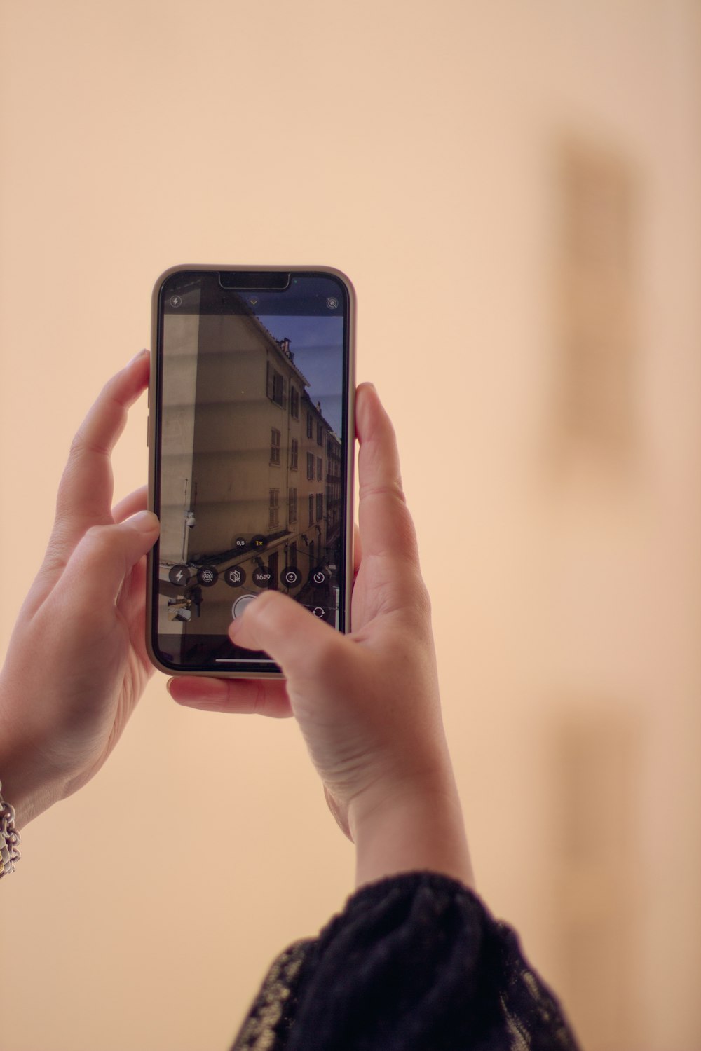 a woman taking a picture of a building with her cell phone