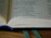 A close-up of an open book with yellowed pages resting on a dark velvet cloth.