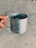 A close-up of a hand holding a gleaming copper tumbler filled with water, sunlight highlighting its rich color.