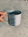 A close-up of a hand holding a gleaming copper tumbler filled with water, sunlight highlighting its rich color.