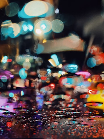 A vibrant street scene at dusk with colorful lights and blurred motion, featuring the 'korback' watermark.