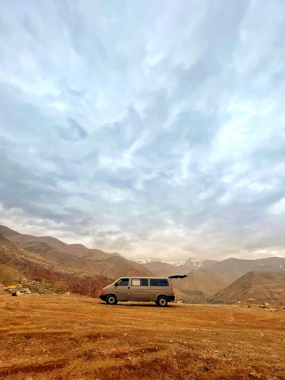 a van is parked in a field with mountains in the background