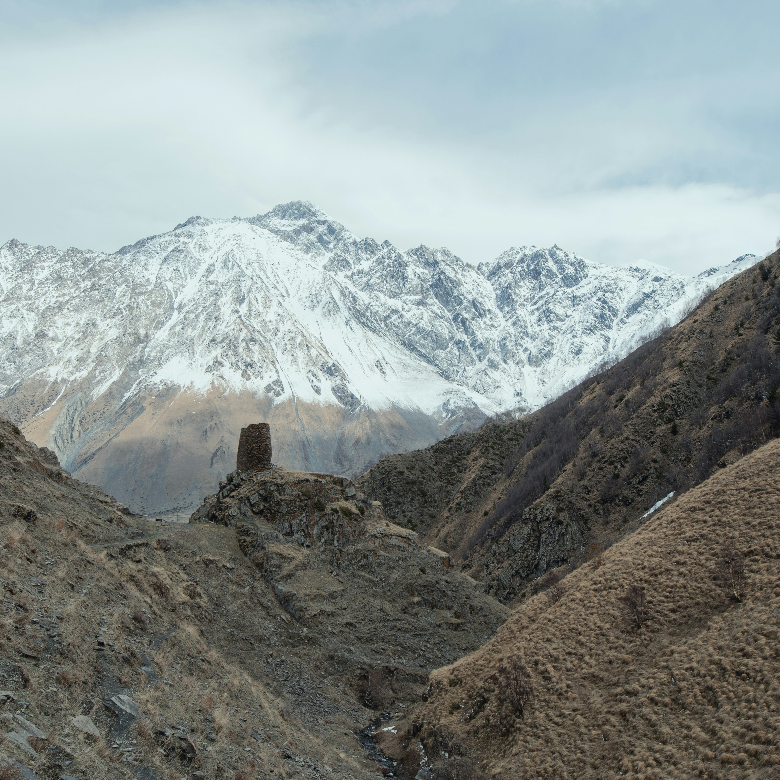 a view of a snowy mountain range from a trail