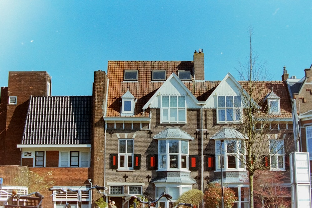 Una hilera de casas con persianas rojas en las ventanas
