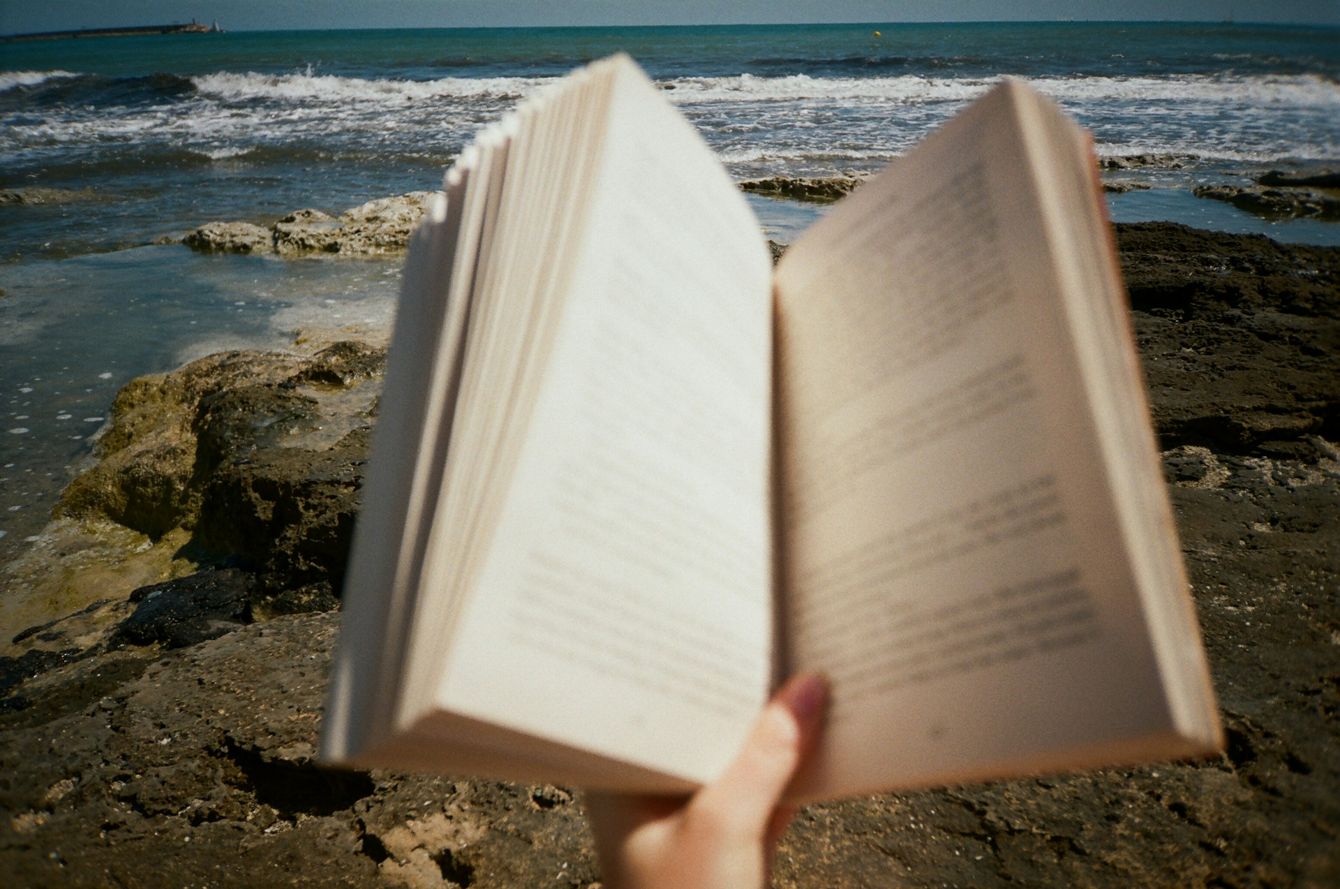 a person holding an open book in their hand