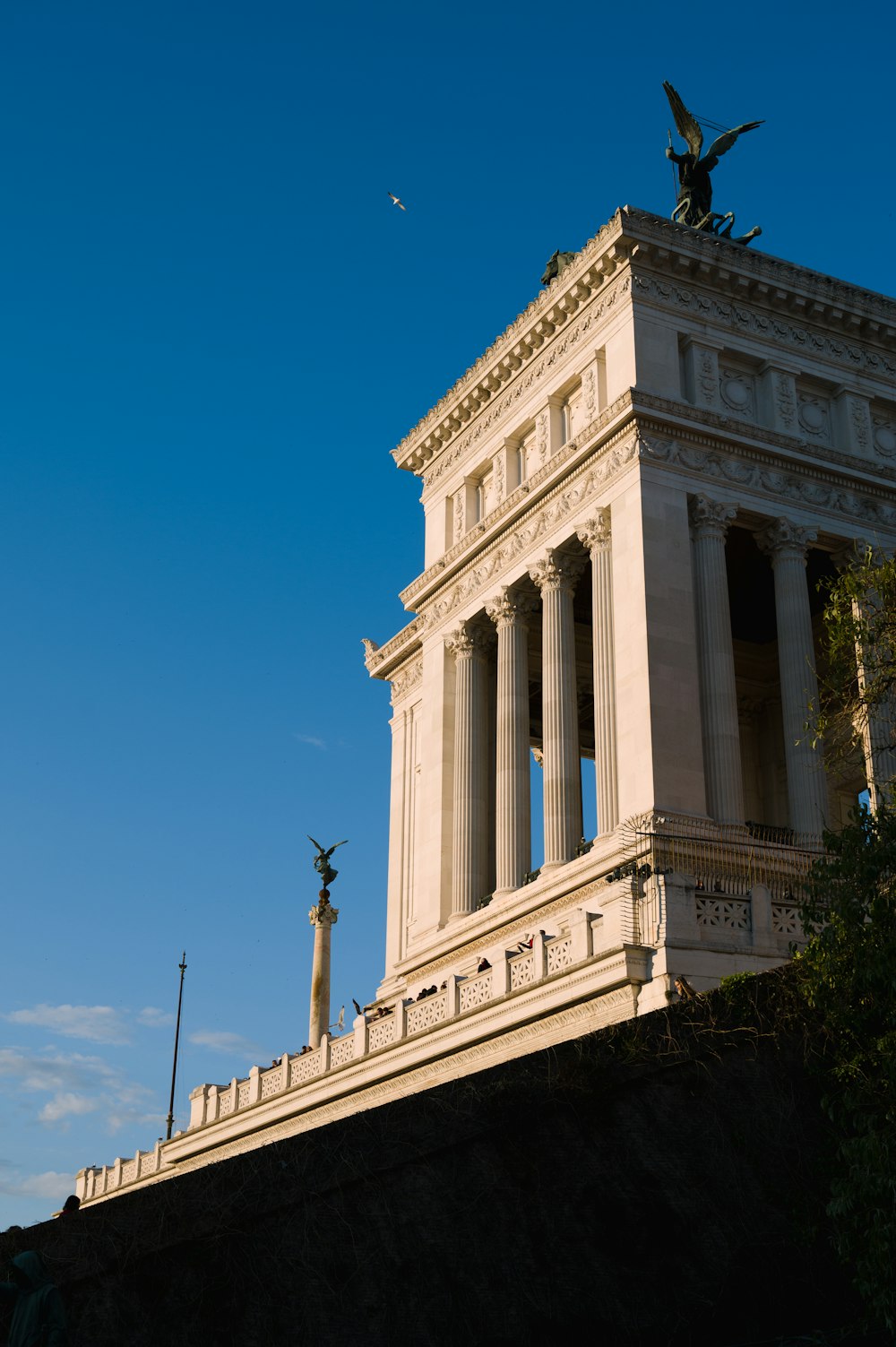 a tall white building with a statue on top of it