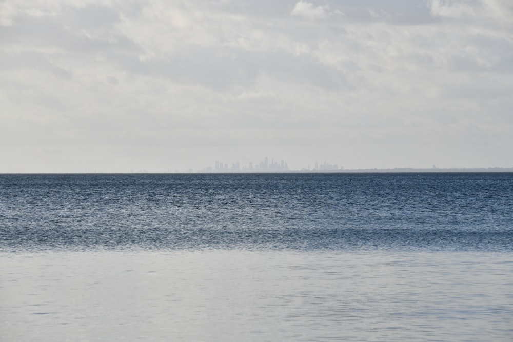 a large body of water with a city in the distance