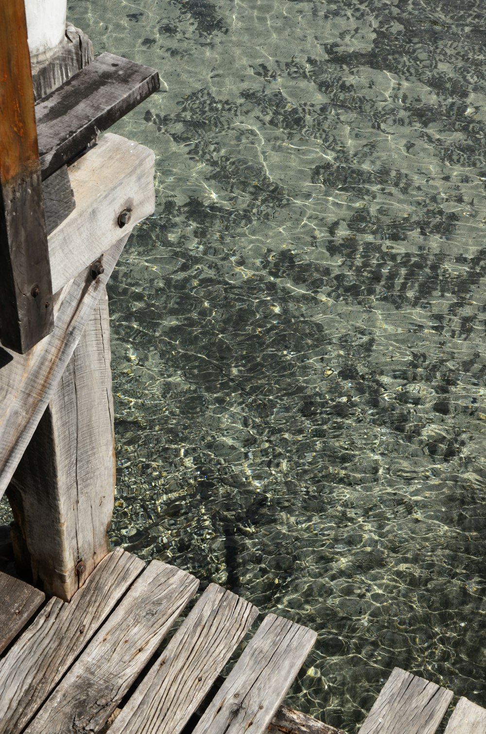 the water is crystal clear and the dock is made of wood