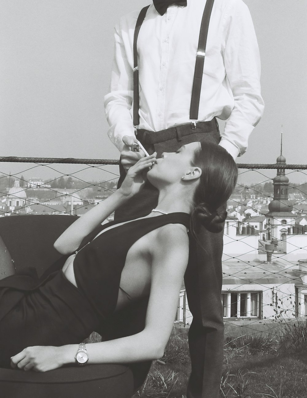 a man standing next to a woman on top of a roof