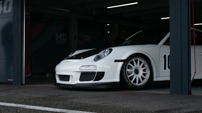 Sleek race car in the garage with telemetry data overlay on the windshield.
