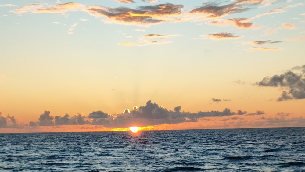 El sol se está poniendo sobre el océano en un día nublado