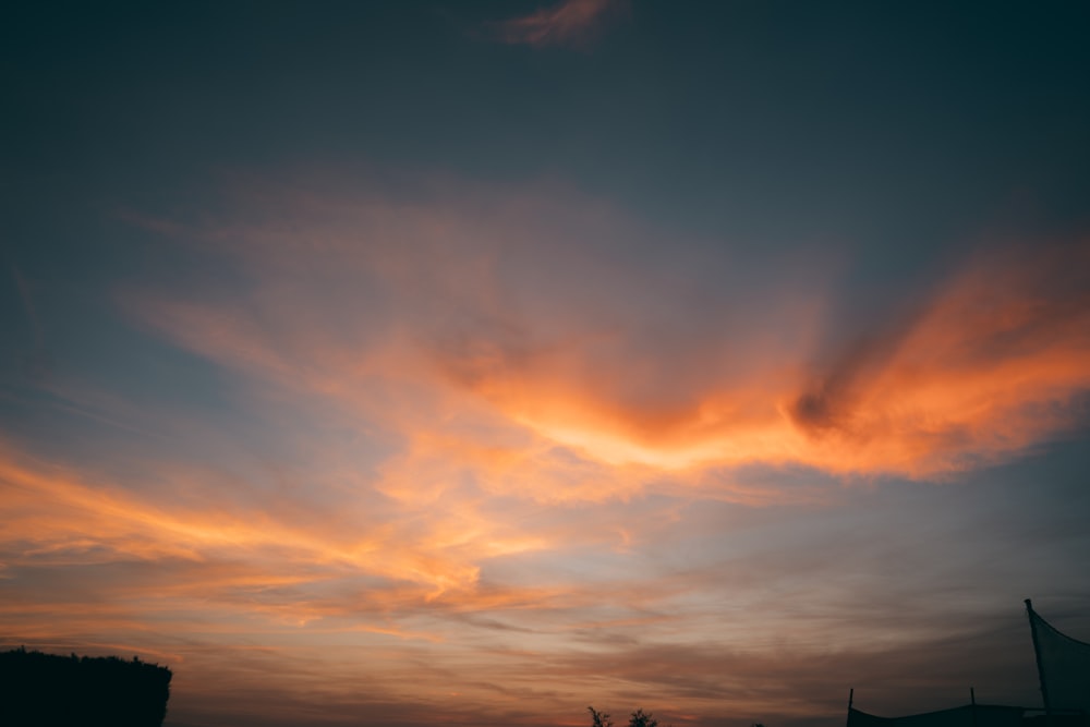 the sun is setting behind a cloud in the sky