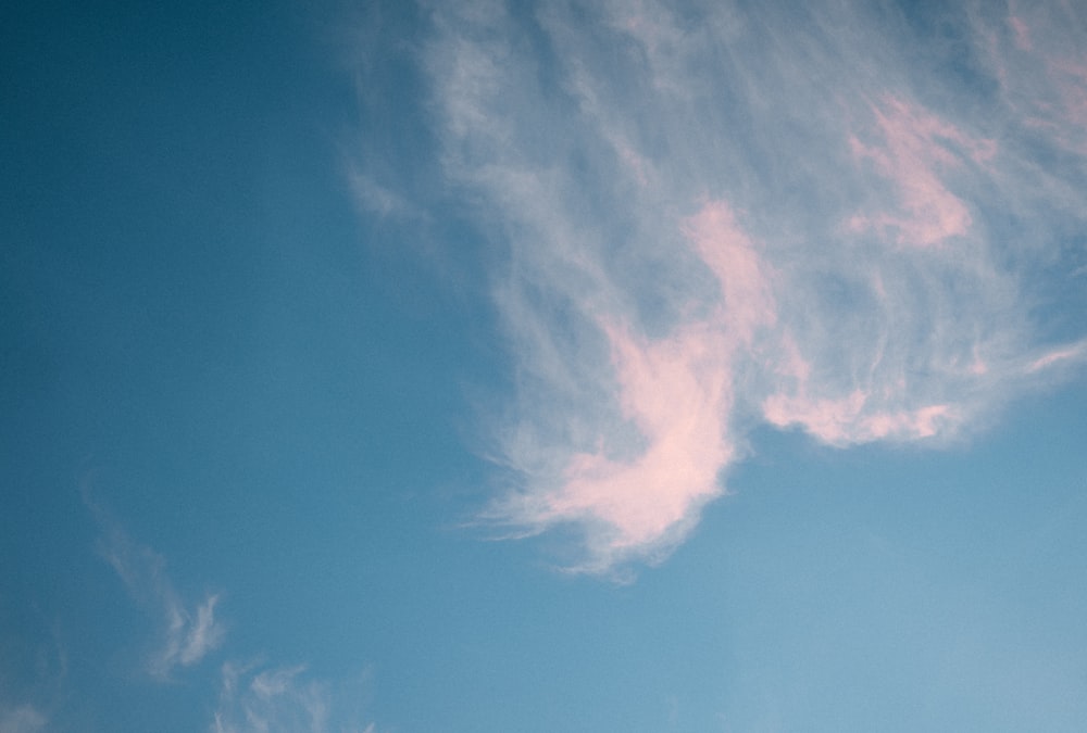 a plane flying through a blue sky with clouds