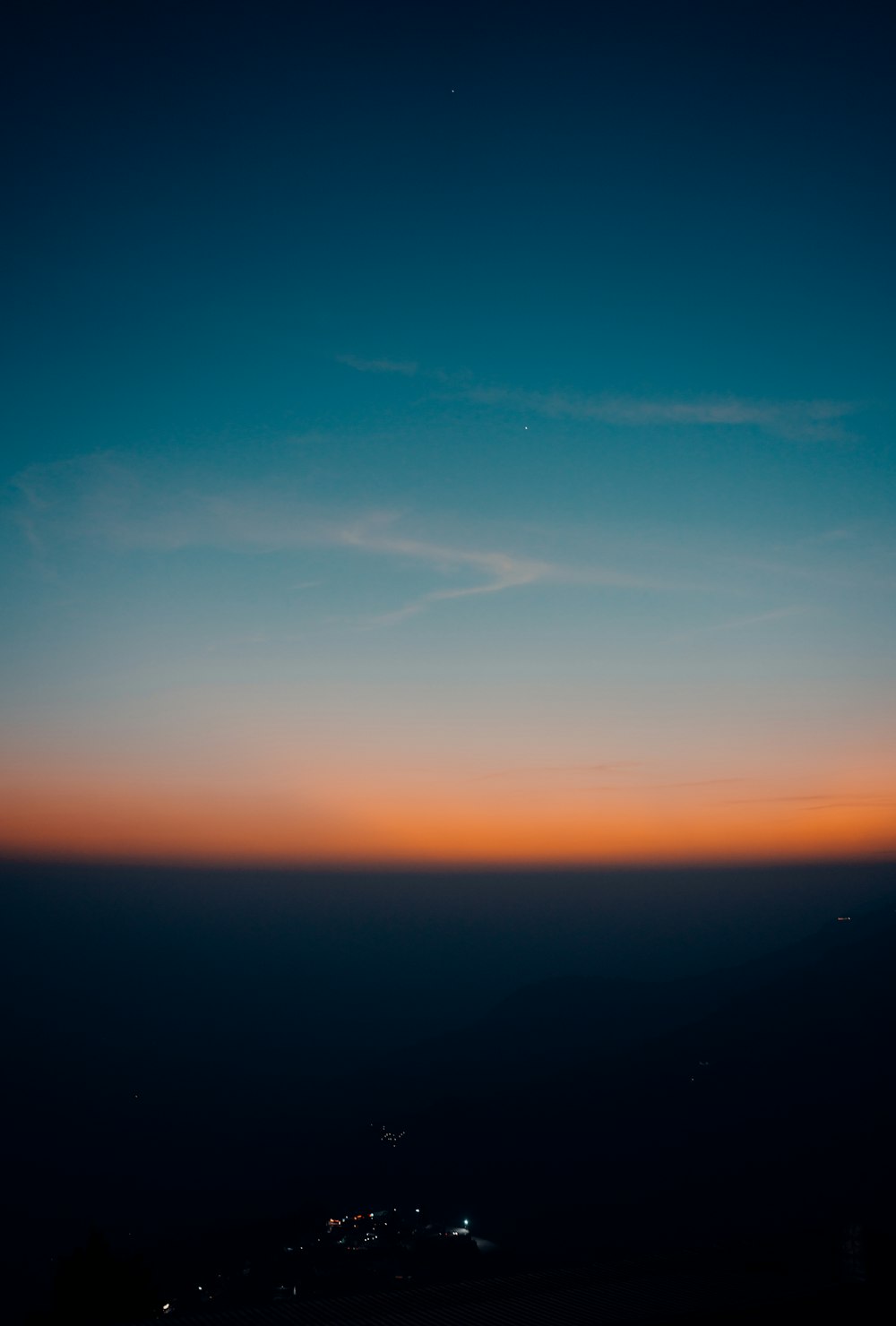 a view of the sky at night from the top of a hill