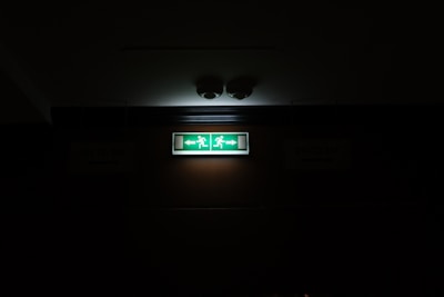An emergency exit sign illuminated in a dim corridor.