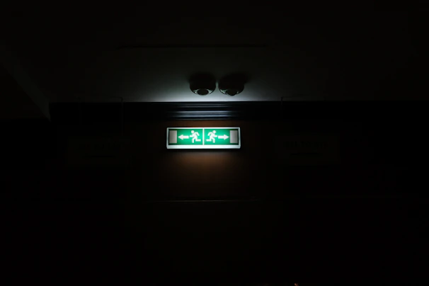 Fire alarm and emergency lighting setup in a commercial building hallway with clear signage