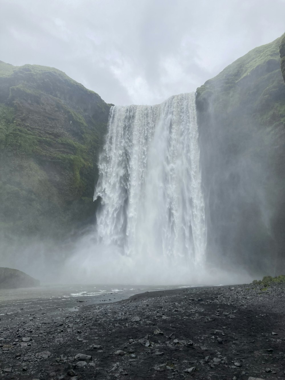 a very tall waterfall in the middle of a mountain