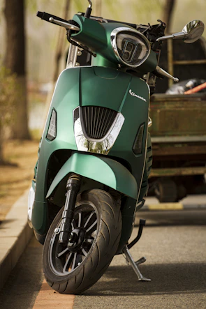 Side view of nerva cargo scooter parked on a city street with modern buildings in the background